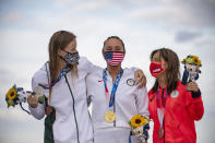 Carissa Moore, center, of the United States, holding her gold medal, South Africa's Bianca Buitendag, left, silver medal and Japan's Amuro Tsuzuki bronze medal celebrate on the podium in the women's surfing competition at the 2020 Summer Olympics, Tuesday, July 27, 2021, at Tsurigasaki beach in Ichinomiya, Japan. (Olivier Morin/Pool Photo via AP)