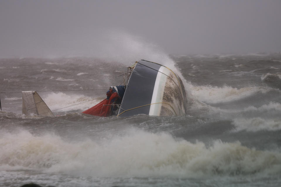 A capsized boat washes ashore as Hurricane Helene churns offshore on September 26, 2024 in St. Petersburg Florida. 