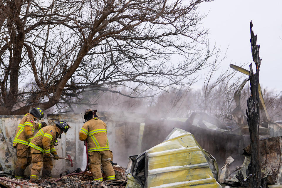 Fire officials from Lubbock, Texas, help put out smoldering debris of a home destroyed by the Smokehouse Creek Fire in Stinnett, on Feb. 29, 2024.<span class="copyright">Julio Cortez—AP</span>