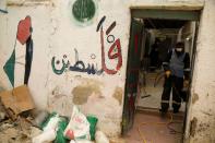 A worker sanitizes a house in al-Fari'ah refugee camp in the Israeli-occupied West Bank