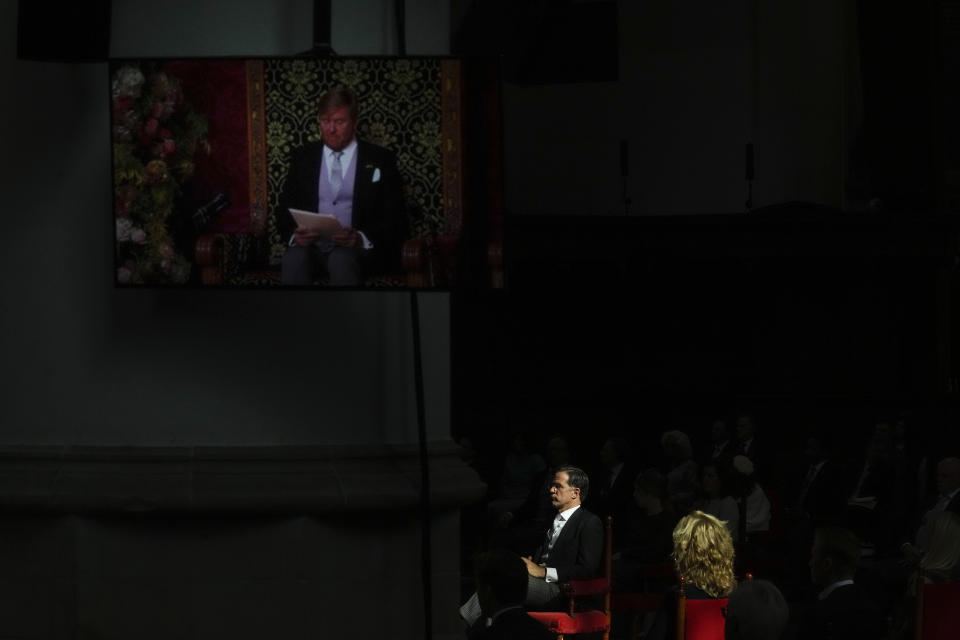 Dutch caretaker Prime Minister Mark Rutte, in the sunlight, listens to King Willem-Alexander's speech, on screen left, which marked the opening of the parliamentary year outlining the government's budget plans for the year ahead at the Grote Kerk, or Sint-Jacobus Kerk, (Great Church or St. James' Church) in The Hague, Netherlands, Tuesday, Sept. 21, 2021. (AP Photo/Peter Dejong)