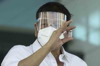 In this photo provided by the Malacanang Presidential Photographers Division, Philippine President Rodrigo Duterte holds a vial containing the Sinovac vaccine from China as it arrives at the Villamor Air Base in Manila, Philippines on Sunday Feb. 28, 2021. The Philippines received its first batch of COVID-19 vaccine Sunday, among the last in Southeast Asia to secure the critical doses despite having the second-highest number of coronavirus infections and deaths in the hard-hit region. (King Rodriguez/ Malacanang Presidential Photographers Division via AP)