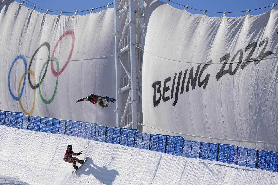 FILE - A snowboarder catches air while training on the half pipe ahead of the 2022 Winter Olympics, Jan. 27, 2022, in Zhangjiakou, China. Beijing will become the first city to host both versions of the Games. (AP Photo/Jae C. Hong, File)