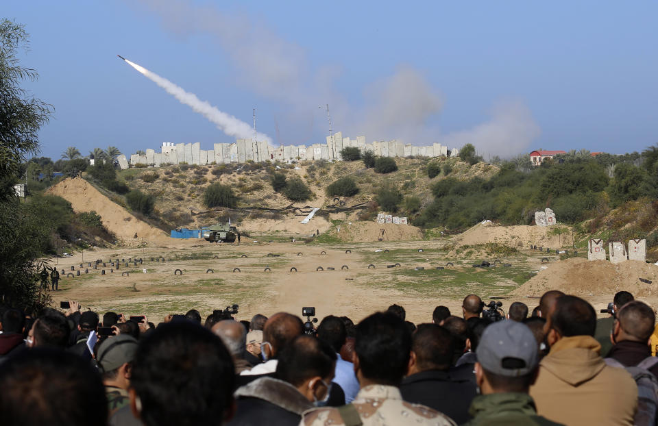 Palestinian militants watch a rocket fired during a military drill organized by military factions outside Gaza City, Tuesday, Dec. 29, 2020. Palestinian militants in the Gaza Strip fired a salvo of rockets into the Mediterranean Sea on Tuesday as part of a self-styled military drill aimed at preparing for a possible war with Israel. (AP Photo/Adel Hana)