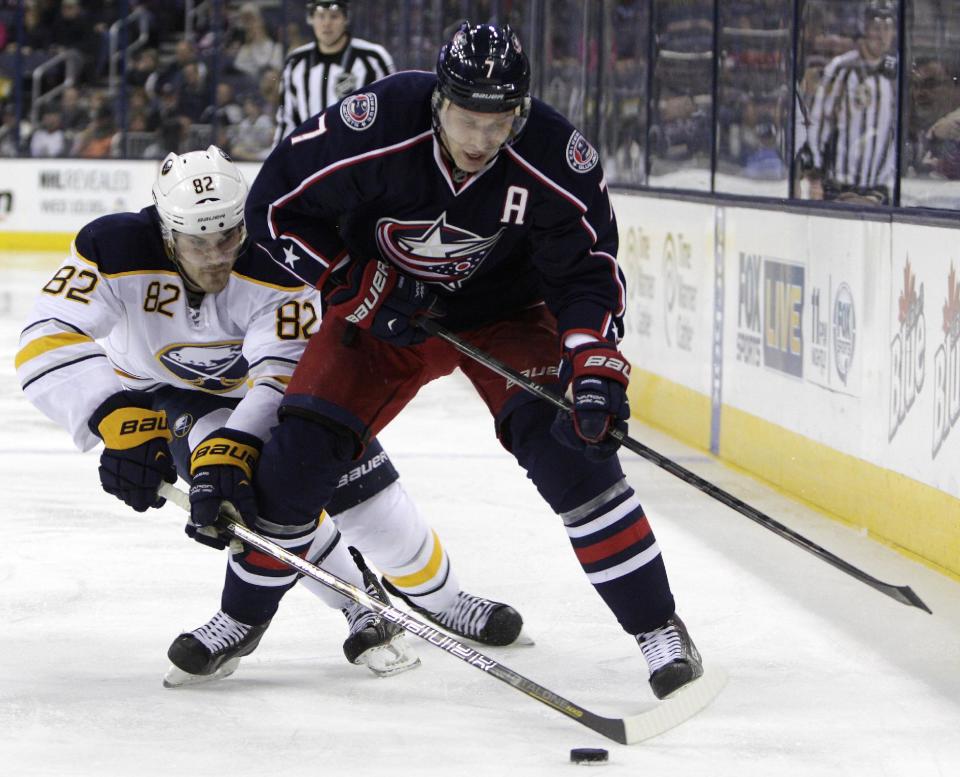 Columbus Blue Jackets' Jack Johnson, right, tries to control the puck as Buffalo Sabres' Marcus Foligno defends during the second period of an NHL hockey game, Saturday, Jan. 25, 2014, in Columbus, Ohio. (AP Photo/Jay LaPrete)