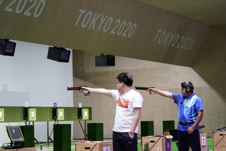 Pang Wei, left, of China, Javad Foroughi, of Iran, compete in the men's 10-meter air pistol at the Asaka Shooting Range in the 2020 Summer Olympics, Saturday, July 24, 2021, in Tokyo, Japan. Foroughi went on to win the gold medal, with Wei taking the bronze. (AP Photo/Alex Brandon)