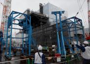 Workers are seen near the No.2 reactor building at sunami-crippled Fukushima Daiichi nuclear power plant in Okuma town, Fukushima prefecture