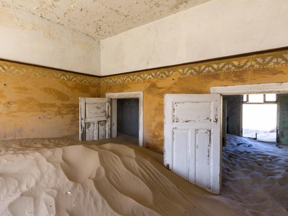 An abandoned room filled with sand in Kolmanskop, Namibia