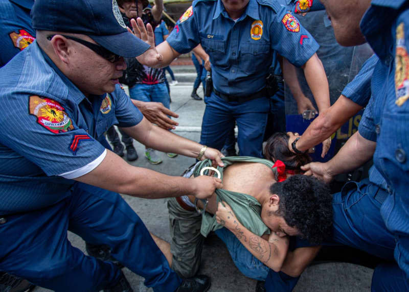 Riot police officers arrest protesters as they attempt to march toward the US embassy, during the Labour Day rally. Jose Monsieur Santos/ZUMA Press Wire/dpa