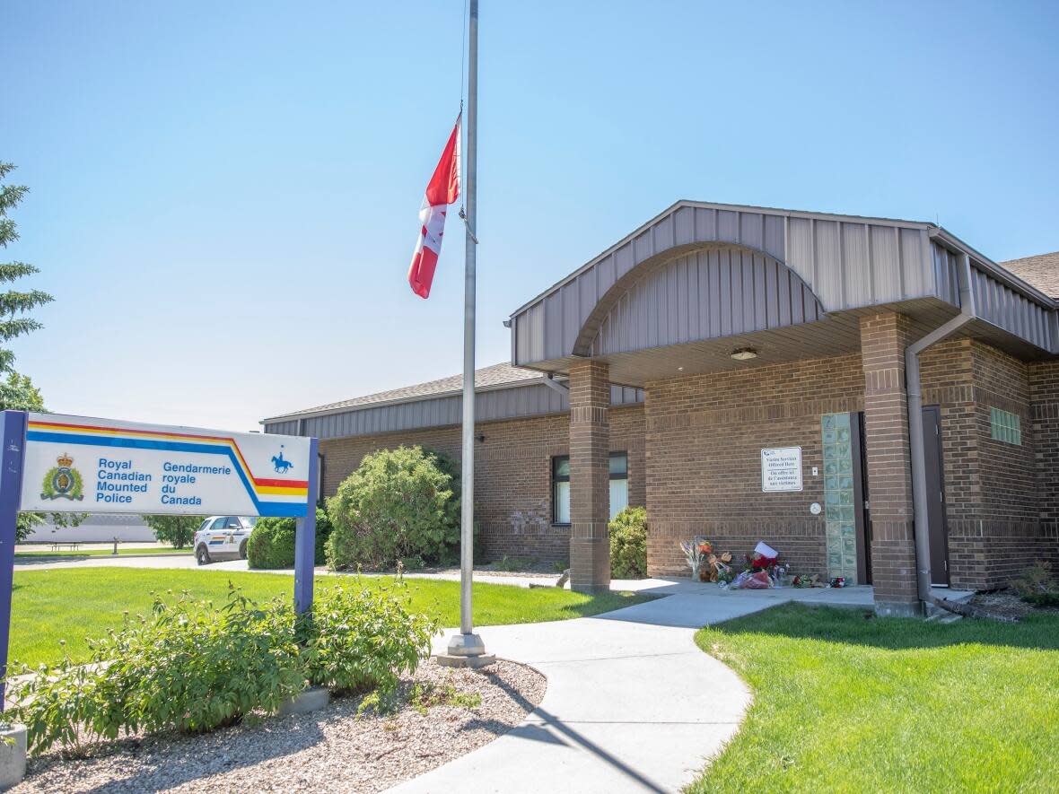 A makeshift memorial for for Const. Shelby Patton, who was killed while on duty in Wolseley, Sask., is laid out beside the RCMP detachment in Indian Head in June. His mother works for the RCMP, and says her co-workers are 'like my angels because if I need someone to talk to, I will have any one of them.' (Kayle Neis/The Canadian Press - image credit)