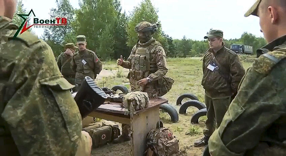 In this photo taken from video released by Belarusian Defense Ministry via VoenTV on Friday, July 14, 2023, an instructor, member of the Wagner Group military company, speaks to Belarusian soldiers during a training near Tsel village, about 90 kilometers (about 55 miles) southeast of Minsk, Belarus. Mercenary fighters from the Wagner private military company are training Belarusian soldiers in Belarus, the country's Defense Ministry said Friday. Russian President Vladimir Putin said he offered the Wagner private military company the option of continuing to serve as a single unit under their same commander. (Belarusian Defense Ministry via VoenTV via AP)