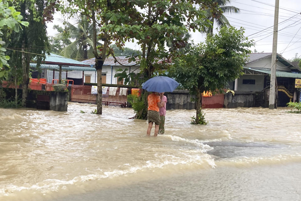 Local residents wade through a flooded road in Bago, about 80 kilometers (50 miles) northeast of Yangon, Myanmar, Monday, Oct.9, 2023. Flooding triggered by heavy monsoon rains in Myanmar’s southern areas has displaced more than 10,000 people and disrupted traffic on the rail lines that connect the country’s biggest cities, officials and state-run media said Monday. (AP Photo/Thein Zaw)