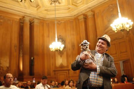 Dog owner Dean Clark presents Frida, a female Chihuahua, as the San Francisco Board of Supervisors issues a special commendation naming Frida "Mayor of San Francisco for a Day" in San Francisco, California November 18, 2014. REUTERS/Stephen Lam