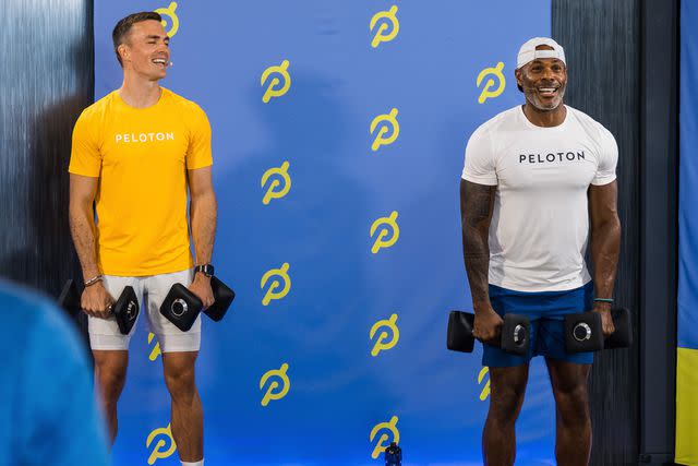 <p>Scott Wild</p> Peloton instructors Ben Alldis and Adrian Williams lifting weights during a Peloton on Tour stop in Los Angeles in July 2023.