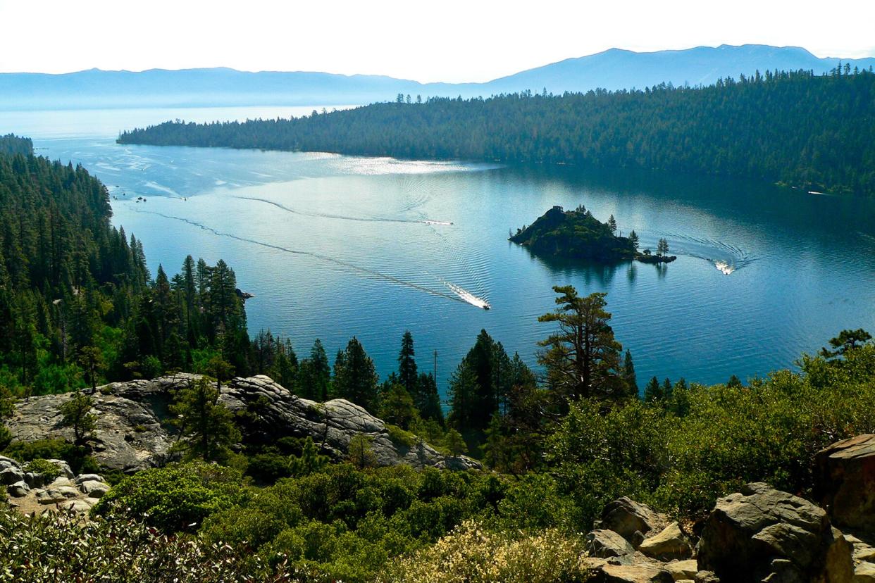 A summer day at Emerald Bay, Lake Tahoe, California. Pleasure boats cruise the calm turquoise blue waters.