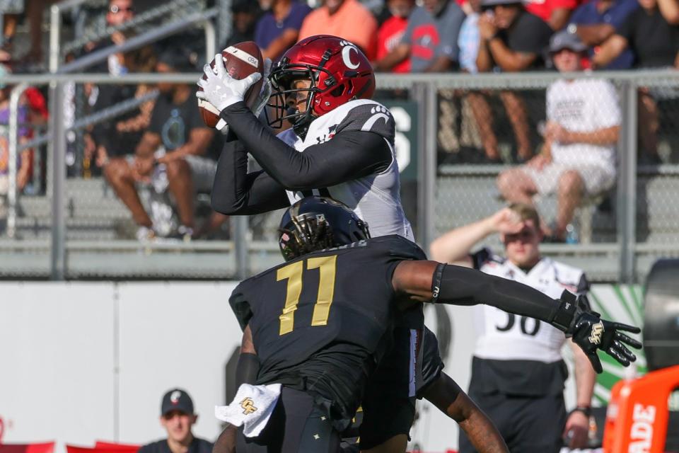 Oct 29, 2022; Orlando, Florida, USA; Cincinnati Bearcats wide receiver Tyler Scott (21) catches a pass as UCF Knights linebacker Jeremiah Jean-Baptiste (11) moves in for the tackle during the second quarter at FBC Mortgage Stadium. Mandatory Credit: Mike Watters-USA TODAY Sports