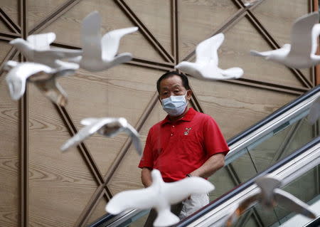 A man wearing a mask to prevent contracting Middle East Respiratory Syndrome (MERS) rides on an escalator in Seoul, South Korea, June 19, 2015. REUTERS/Kim Hong-Ji