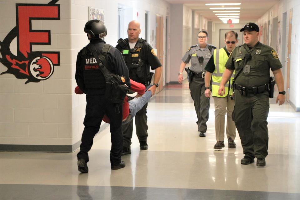 Marion County law enforcement officers and emergency medical personnel transport one of the Elgin Local Schools staff members who portrayed a shooting victim to a safe staging area at the front of the school building during the active shooter incident scenario held Wednesday May 17, 2023.
