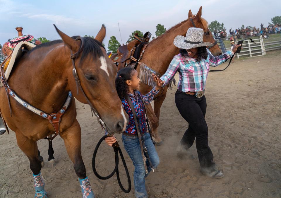 Staci Russell, 39, of Belleville, gives a five to Amarissa Hughes, 7, of Chicago, as Russell walks her horse, Reese's Cup, while making their way back to their trailers during the second day of the 2023 Midwest Invitational Rodeo at the Wayne County Fairgrounds in Belleville on Saturday, June 10, 2023. Russell travels with Hughes and her family to rodeos, where Russell and her father compete as well.