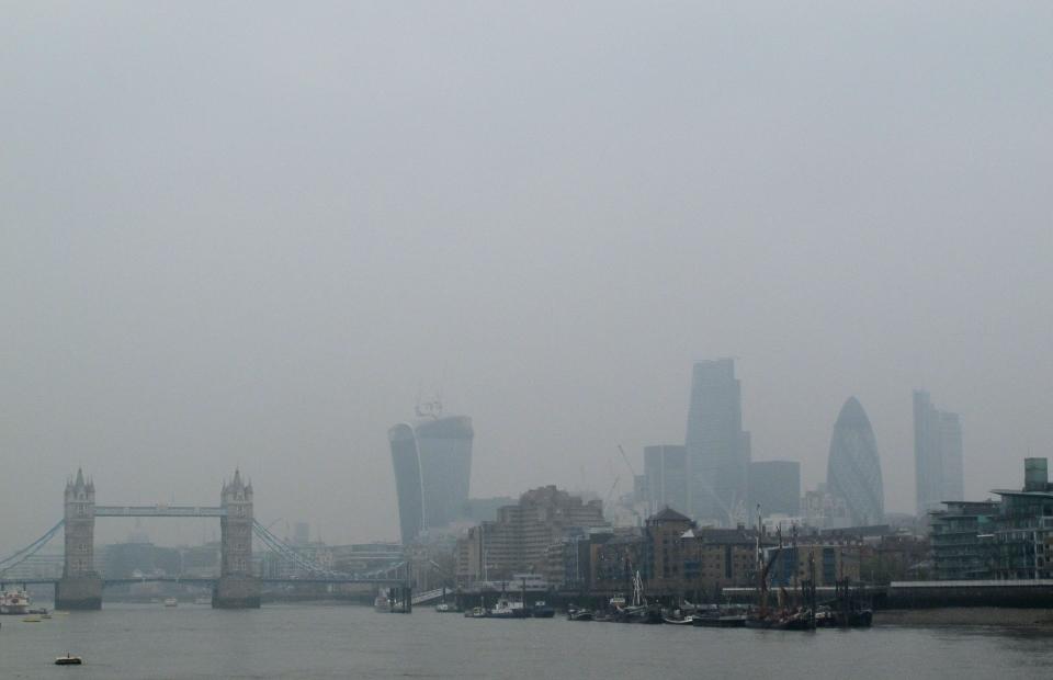 Tower Bridge and the high rise towers of the City of London are shrouded in smog Thursday April 4, 2014. European pollution and dust swirling in from the Sahara has created a "perfect storm" of smog as it continued in Britain on Thursday, prompting authorities to warn people with heart or lung conditions to cut down on tough physical exercise outdoors. (AP Photo/Tony Hicks)