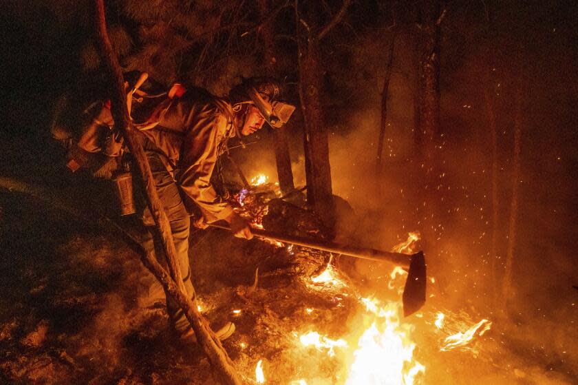 Firefighter Christian Mendoza manages a backfire, flames lit by firefighters to burn off vegetation, while battling the Mosquito Fire in Placer County, Calif., on Tuesday, Sept. 13, 2022. (AP Photo/Noah Berger)