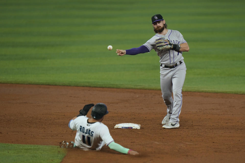 Colorado Rockies second baseman Brendan Rodgers throws to first for a double play after tagging second to put out Miami Marlins' Miguel Rojas (11) then Nick Fortes at first during the second inning of a baseball game, Thursday, June 23, 2022, in Miami. (AP Photo/Wilfredo Lee)