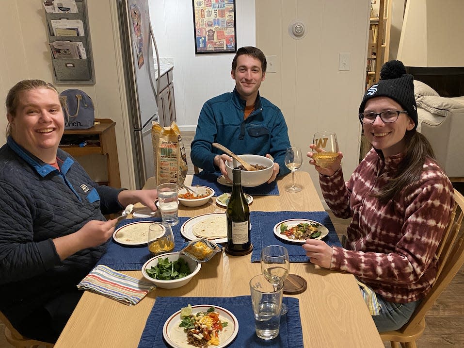 Abby and her travel companions sitting around a table and eating dinner