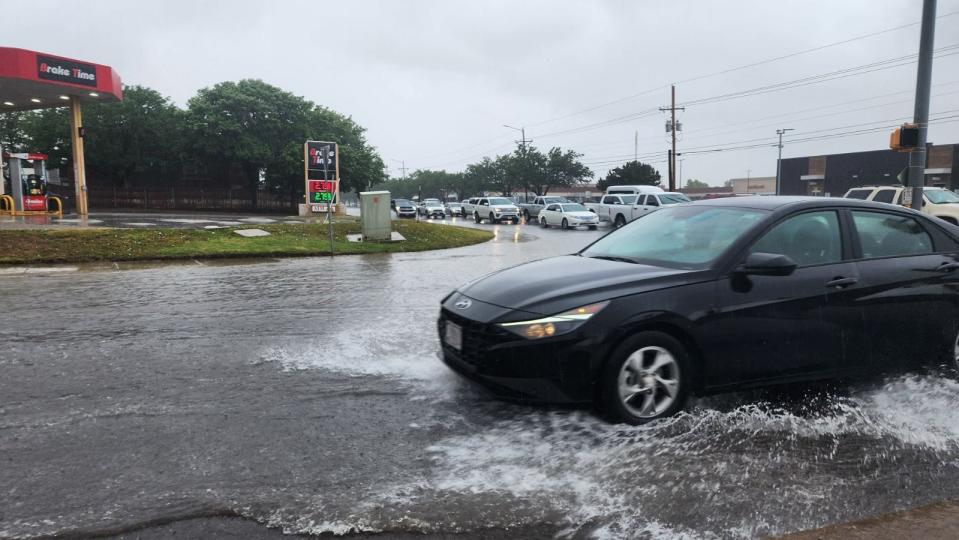 Vehicles drive through a flooded intersection at 34th and Coulter in Amarillo on Monday afternoon.