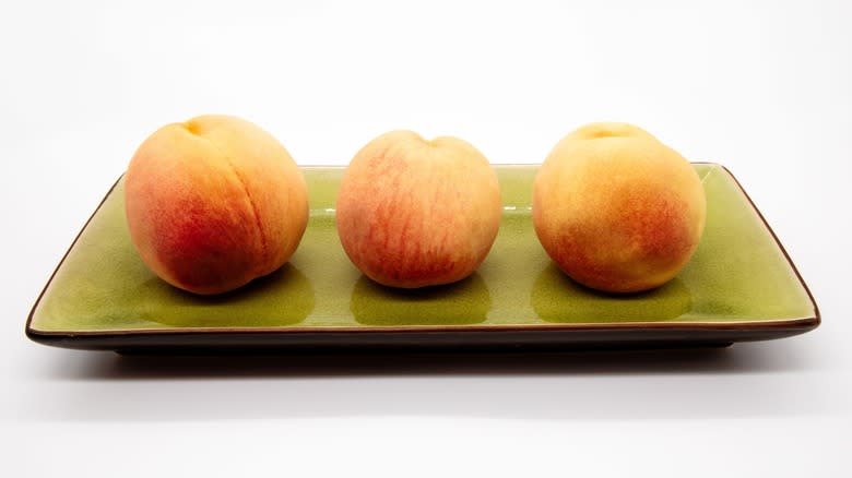 Three peaches on a plate