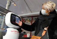 A machine checks a woman's vaccine pass, at a restaurant in Lille, northern France, Monday, Jan. 24, 2022. Unvaccinated people are no longer allowed in France's restaurants, bars, tourist sites and sports venues, as a new law came into effect Monday requiring a "vaccine pass" that is central to the government's anti-virus strategy. (AP Photo/Michel Spingler)