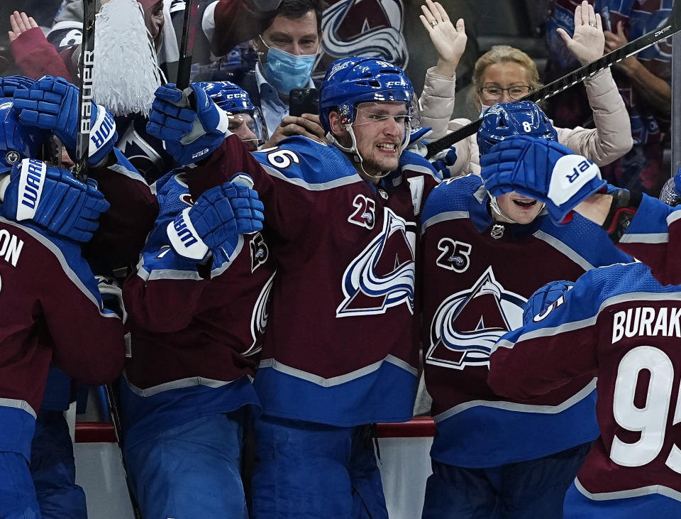 Colorado Avalanche right wing Mikko Rantanen, center, is congratulated by teammates after scoring in overtime against the Vegas Golden Knights during Game 2 of an NHL hockey Stanley Cup second-round playoff series Wednesday, June 2, 2021, in Denver. (AP Photo/Jack Dempsey)