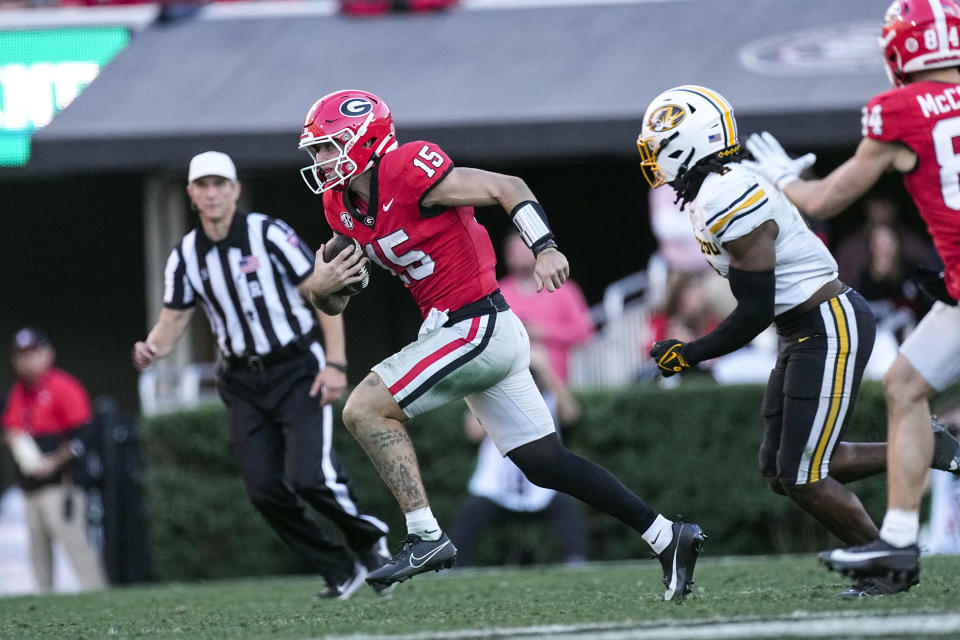 Georgia quarterback Carson Beck (15) runs from Missouri linebacker Ty'Ron Hopper (8) during the first half of an NCAA college football game, Saturday, Nov. 4, 2023, in Athens, Ga. (AP Photo/John Bazemore)