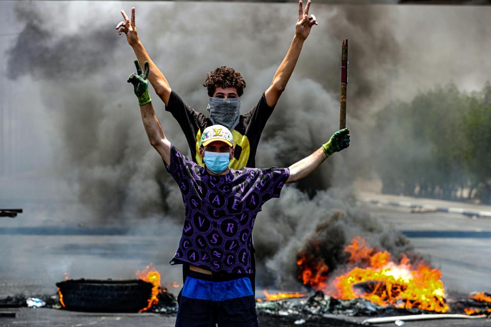 Protesters burn tires to block roads during a demonstration demanding the return of electricity in Basra, southeast of Baghdad, Iraq, Friday, July 2, 2021. A widespread power outage is hitting Iraq as temperatures reach scorching levels, affecting even affluent areas in the capital and stirring concerns of widespread unrest. (AP Photo/Nabil al-Jurani)