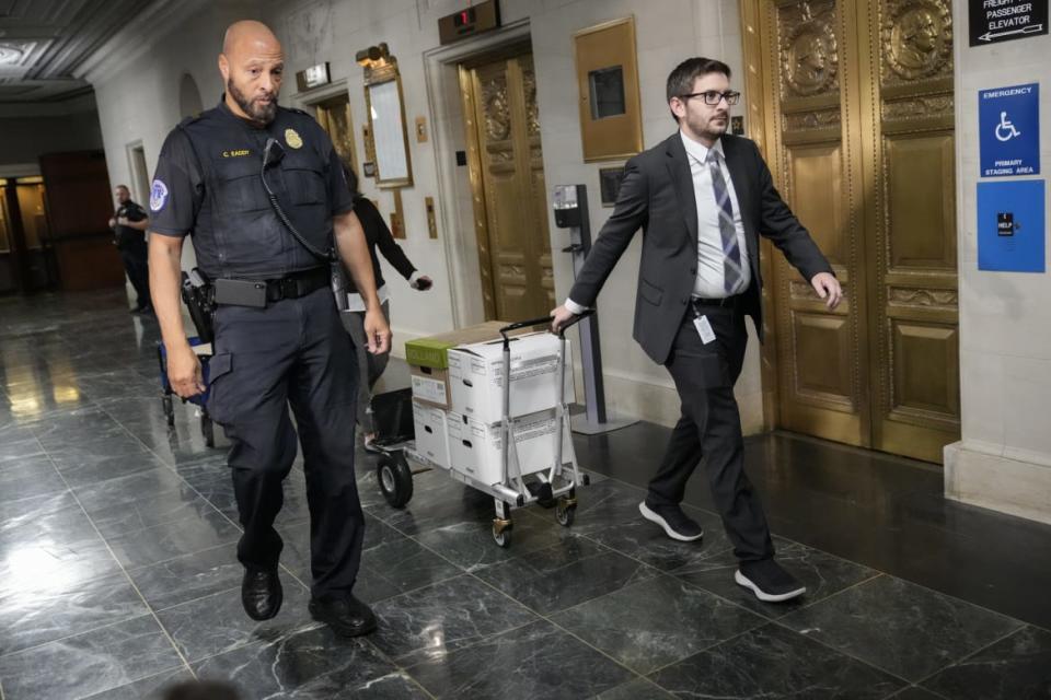 <div class="inline-image__caption"><p>Escorted by a Capitol Police officer, staff members move boxes of documents from a hearing room to an office following a meeting of the House Ways and Means Committee, in which members voted on party lines to release former President Donald Trump's tax returns to the public.</p></div> <div class="inline-image__credit">Drew Angerer/Getty Images</div>