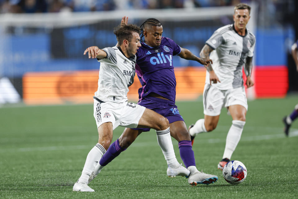 Charlotte FC forward Kerwin Vargas, center, works against Toronto FC midfielder Kobe Franklin for the ball during the second half of an MLS soccer match in Charlotte, N.C., Wednesday, Oct. 4, 2023. (AP Photo/Nell Redmond)