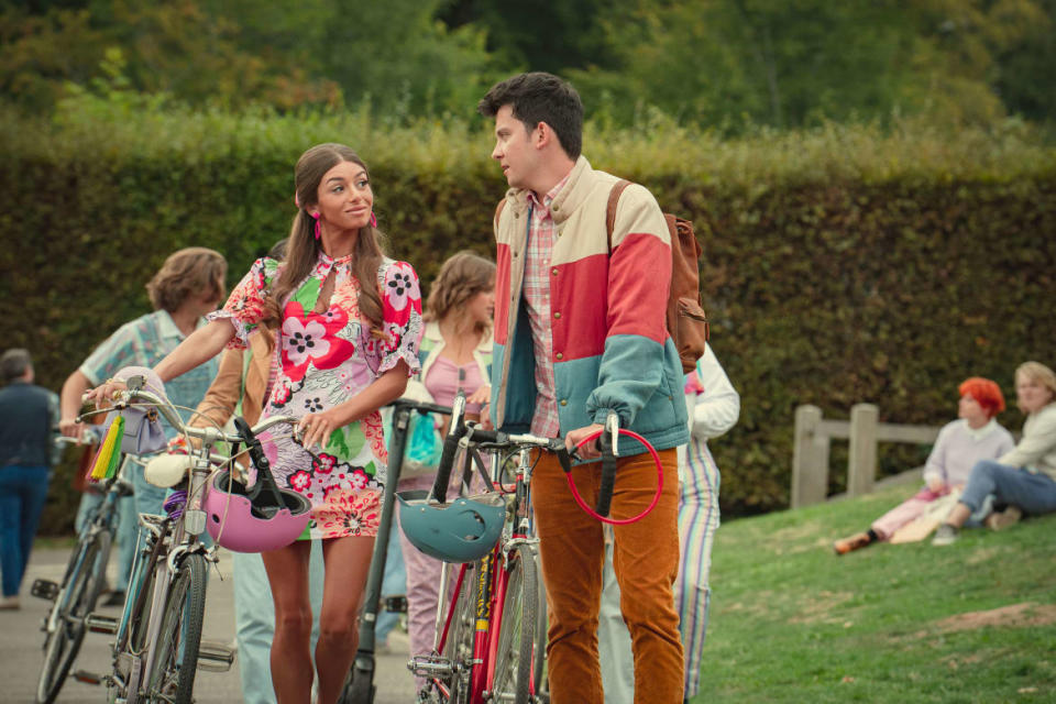 Mimi Keene and Asa Butterfield walking bikes in ‘Sex Education’