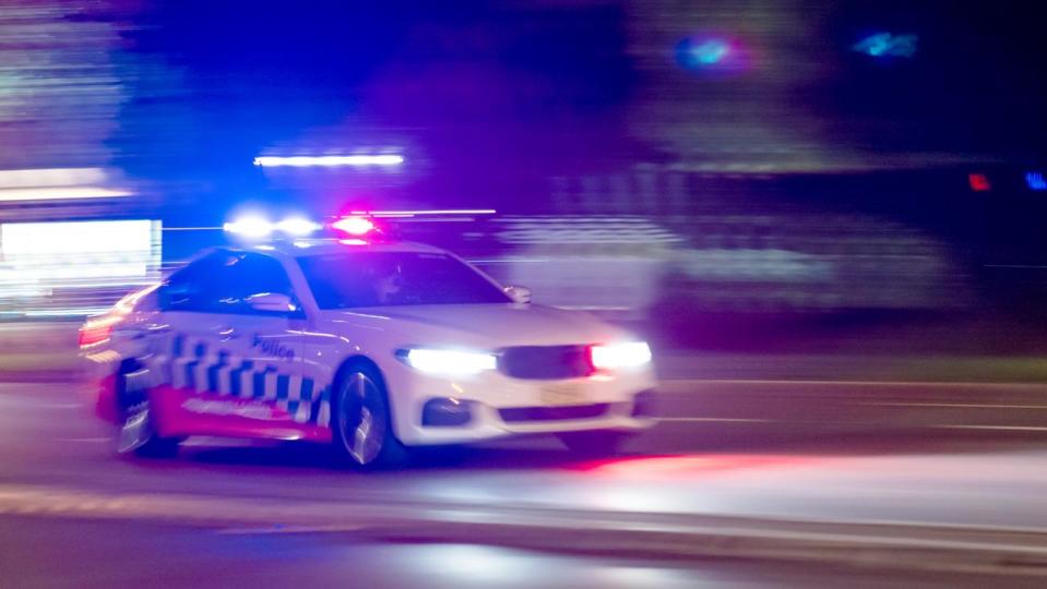 A police car races to the scene of an incident, Sydney