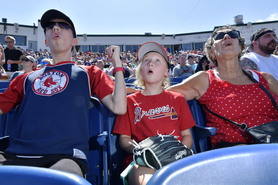 From left, Wyatt Smith, 17, of Waterville, Maine, Tessa Dutil, 9, of Sidney, Maine, and their grandmother Anne Smith, of Watervillle, Maine, react to a hit during the game between the Portland Sea Dogs and the Hartford Yard Goats, Sunday, August 28, 2022, at Hadlock Field in Portland, Maine. Across the northeastern U.S., outdoor businesses are profiting from the unusually dry weather. (AP Photo/Josh Reynolds)