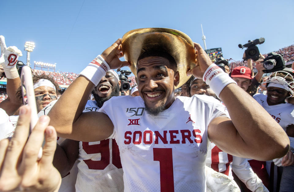 Oklahoma quarterback Jalen Hurts (1) puts on the Golden Hat after beating Texas 34-27 in an NCAA college football game at the Cotton Bowl, Saturday, Oct. 12, 2019, in Dallas. (AP Photo/Jeffrey McWhorter)