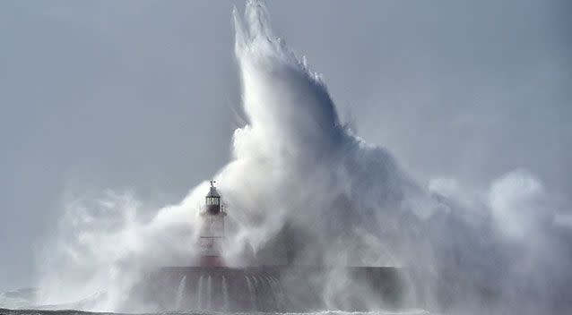 Waves crash over Newhaven Lighthouse on the south coast of England. Source: AAP