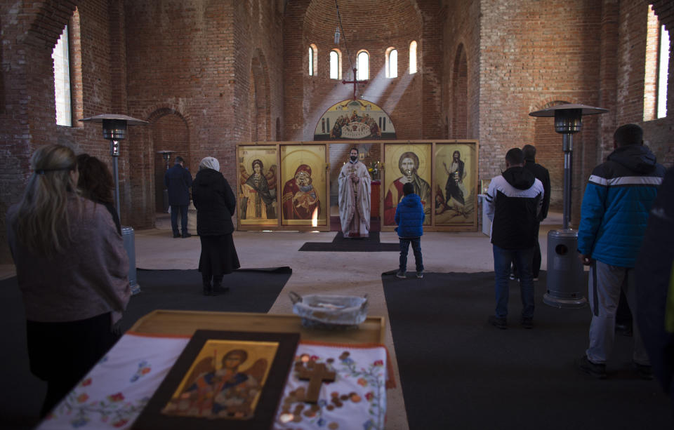 In this Sunday, March 17, 2019 photo, a church service is held at an Orthodox church in the Bosnian Serb wartime stronghold of Pale, Bosnia-Herzegovina. Nearly a quarter of a century since Bosnia's devastating war ended, former Bosnian Serb leader Radovan Karadzic is set to hear the final judgment on whether he can be held criminally responsible for unleashing a wave of murder and mistreatment by his administration's forces. United Nations appeals judges on Wednesday March 20, 2019 will decide whether to uphold or overturn Karadzic's 2016 convictions for genocide, crimes against humanity and war crimes and his 40-year sentence. (AP Photo/Darko Bandic)