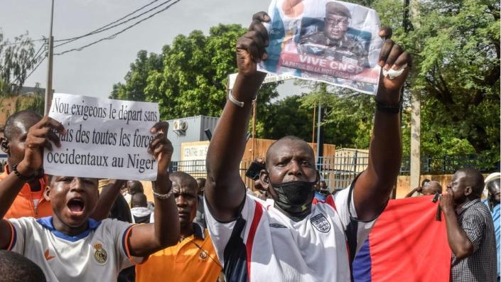 A supporter holds a picture of Niger General Abdourahamane Tiani, the chief of the powerful presidential guard, as with others rally in support of Niger&#39;s junta in Niamey on July 30, 2023