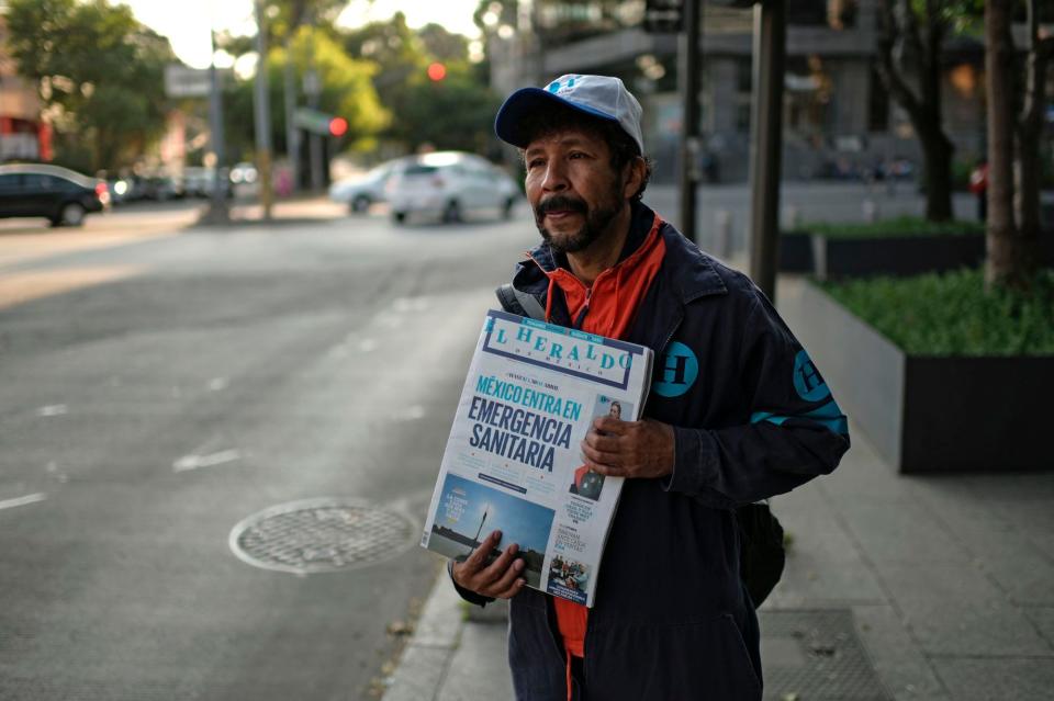 A newsboy holds a newspaper which headline reads Mexico enters health emergency at Polanco neighborhood in Mexico City on March 31, 2020, during the outbreak of the novel coronavirus COVID-19. (Photo by PEDRO PARDO / AFP) (Photo by Images)