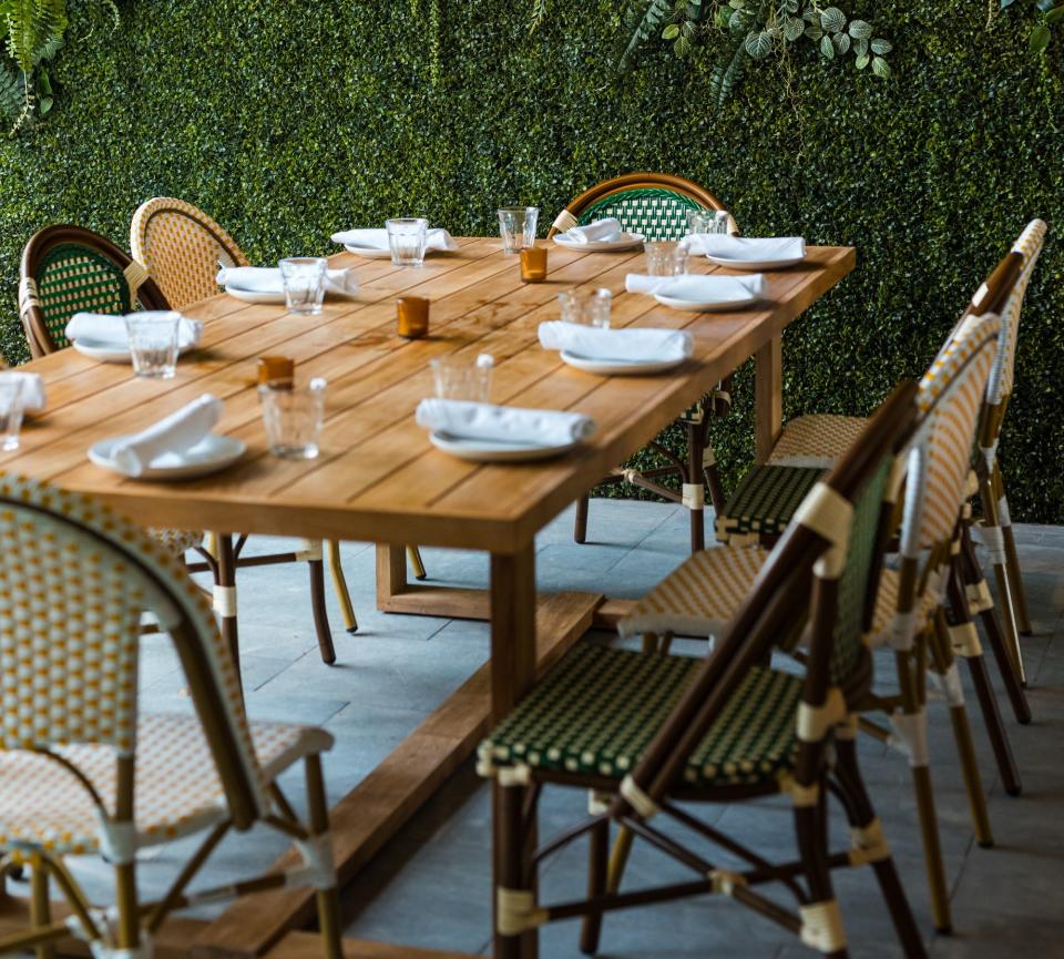 The al fresco patio at the new NiMo Coastal Mediterranean offers a large, leafy area for dining. A retractable roof helps keep the elements at bay.