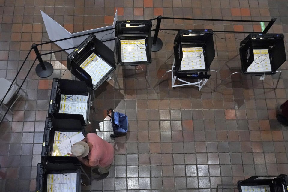 FILE - A voter fills out his ballot, Monday, Aug. 8, 2022, at the Stephen P. Clark Government Center in Miami. Florida Gov. Ron DeSantis' effort to place candidates fully aligned with his conservative views on school boards throughout the state is helping him expand his influence. Of the 30 candidates endorsed by DeSantis in the Aug. 23 elections, 19 won, five lost and six are headed to runoffs. (AP Photo/Wilfredo Lee, File)