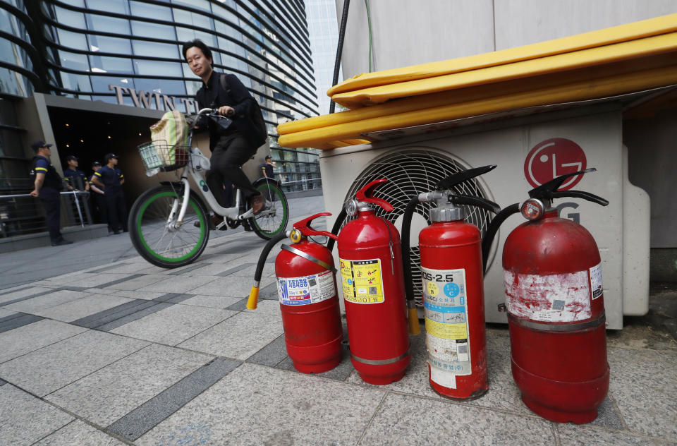 Fire extinguishers are placed near a building where the Japanese embassy is located in Seoul, South Korea, Friday, July 19, 2019. South Korean police say a man has set himself on fire in front of the Japanese Embassy in Seoul amid rising trade disputes between Seoul and Tokyo. (AP Photo/Ahn Young-joon)
