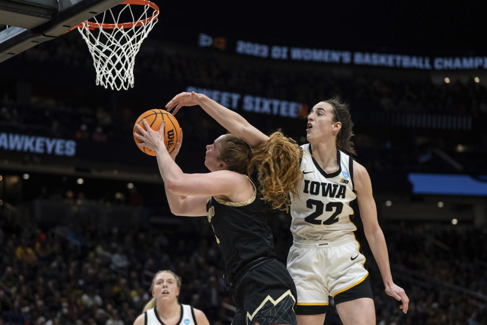 Colorado guard Frida Formann, left, goes up for a shot against Iowa guard Caitlin Clark (22) during the first half of a Sweet 16 college basketball game in the women's NCAA tournament Friday, March 24, 2023, in Seattle. (AP Photo/Stephen Brashear)