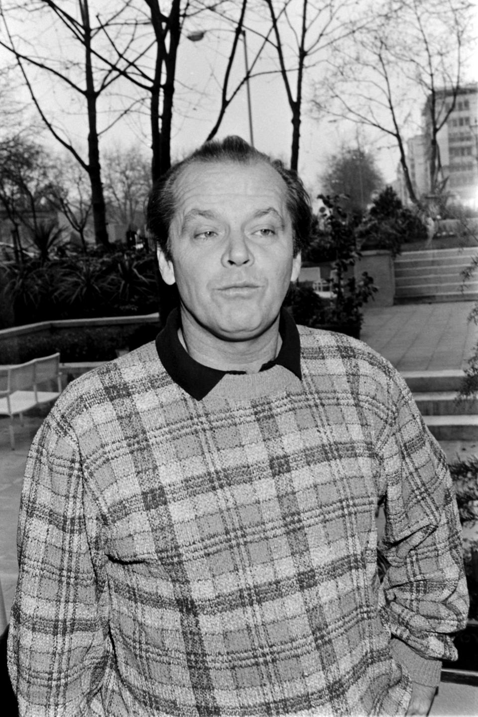 A man in a plaid jacket makes a playful face at the camera
