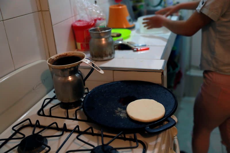 Diego Alvarez and his girlfriend Jetsymar Torres from Venezuela cook traditional Venezuelan breakfast at their house in Bogota