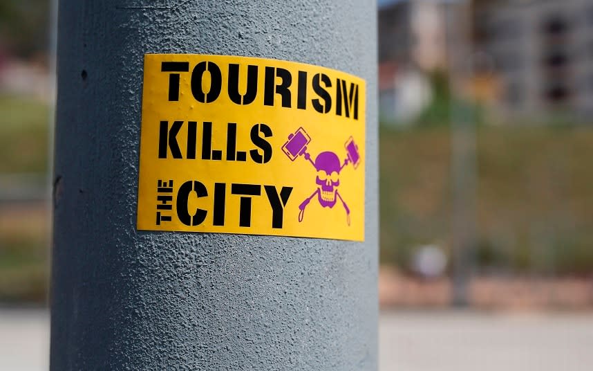 An anti-tourism sticker adorns a lamp-post in Barcelona - This content is subject to copyright.